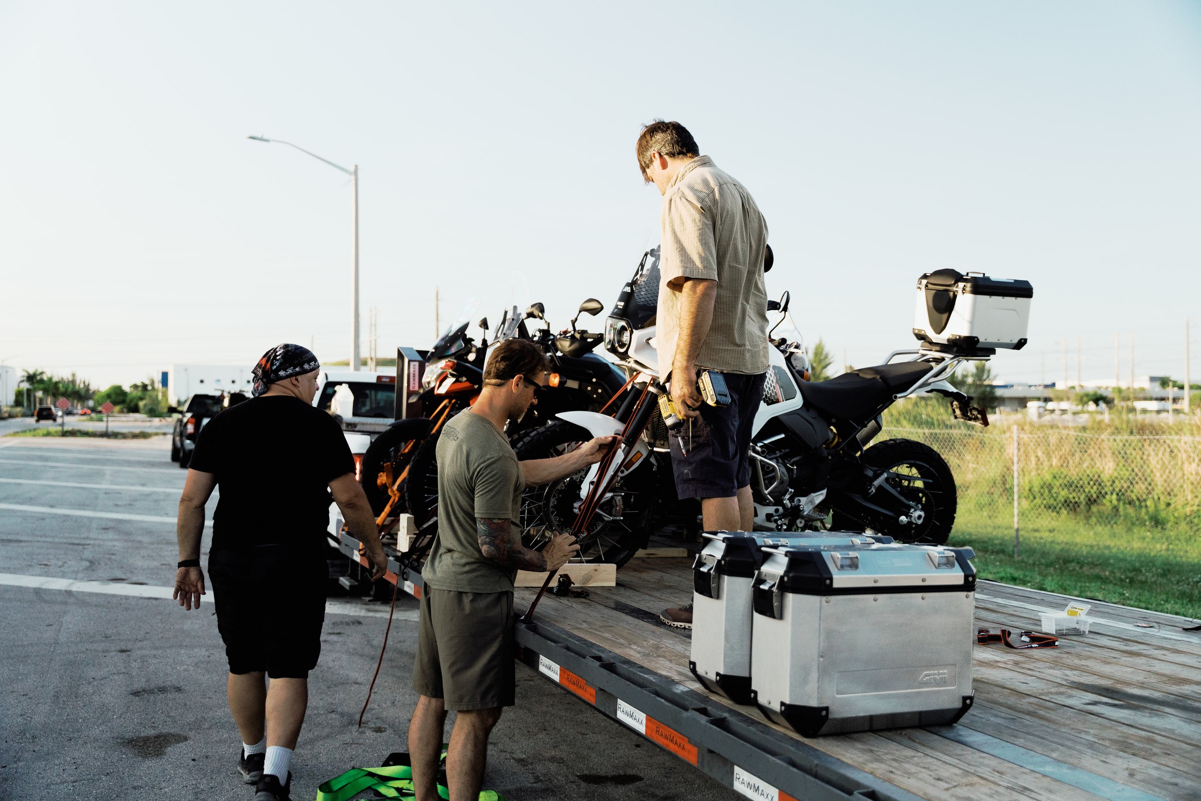 Crew loading motorcycles onto a transport trailer